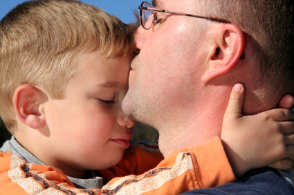 Dad kissing son